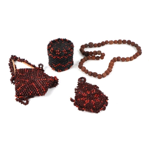 130 - A collection of small tribal items to include a Rudraksha Mala carved bead necklace and seed work pu... 