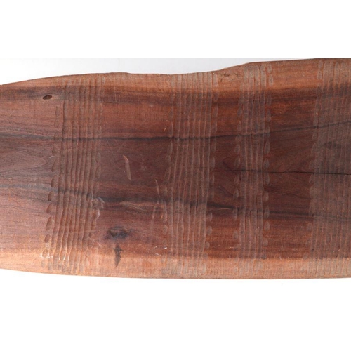 131 - An Australian Aboriginal wooden shield with incised decoration to front and rear, 75cms long.