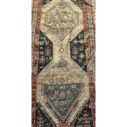 171 - A Persian hand knotted runner with repeating geometric motifs on a multi coloured ground within a bo... 