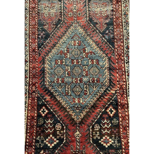 171 - A Persian hand knotted runner with repeating geometric motifs on a multi coloured ground within a bo... 