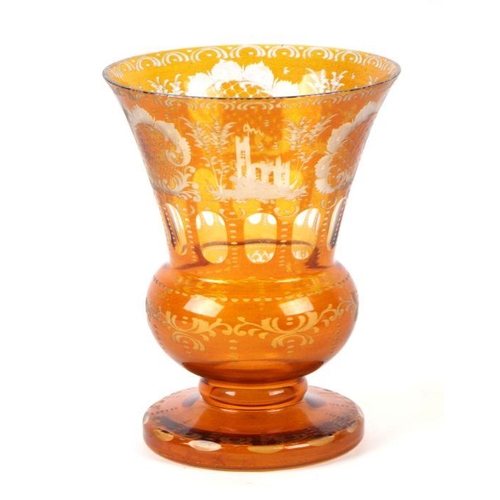 288 - A Bohemian amber flashed glass vase with acid etched decoration depicting a church within a landscap... 