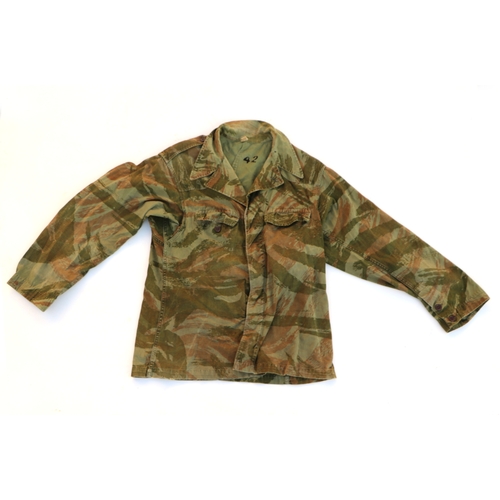 97 - A quantity of assorted military uniform to include winter jackets and other similar items.