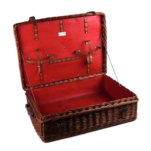 123 - An early 20th century Coracle wicker picnic basket with red Retsine interior, leather carrying handl... 