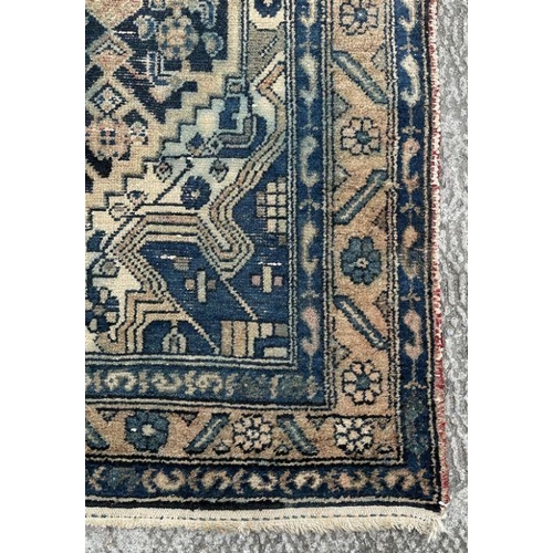 269 - A Persian rug with central medallion on a blue ground, within a multi border, 233 by 132cms.