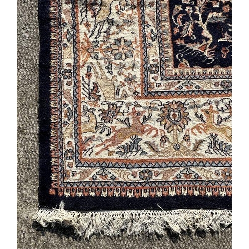 276 - A large Persian rug decorated with figures on horseback, on a blue ground, 312 by 442cms.