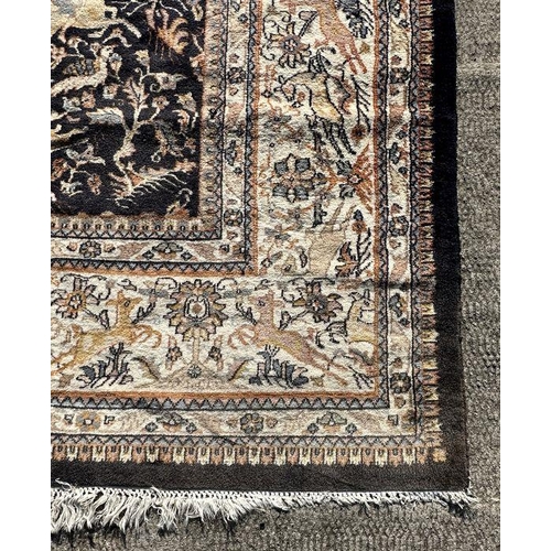 276 - A large Persian rug decorated with figures on horseback, on a blue ground, 312 by 442cms.