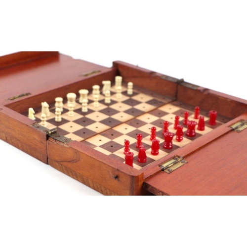 503 - A travelling chess set in a folding mahogany case (lacks one pawn), 20cms wide.