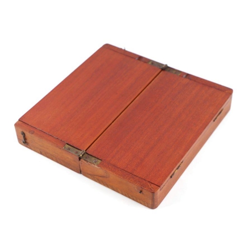 503 - A travelling chess set in a folding mahogany case (lacks one pawn), 20cms wide.