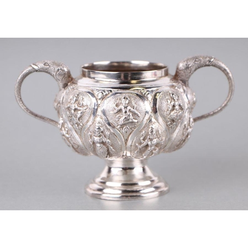 555 - An Indian silver coloured metal sugar bowl and cream jug with repousse decoration, 256g (2).