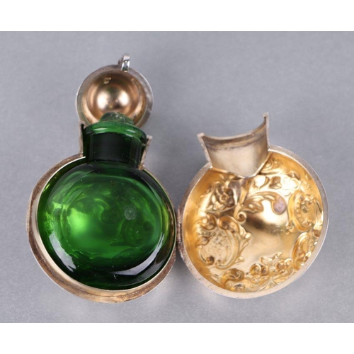 562 - A Victorian silver scent bottle case with green glass scent bottle, the case with repousse decoratio... 