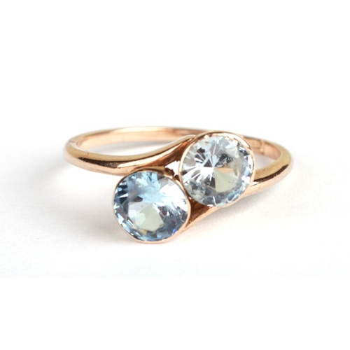 647 - A 9ct gold two-stone crossover ring set with pale blue stones, approx UK size 'K', 2.2g.