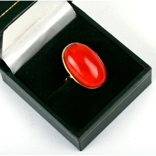 652 - An 18ct gold ring set with a large coral cabochon, approx UK size 'O', 6.7g.