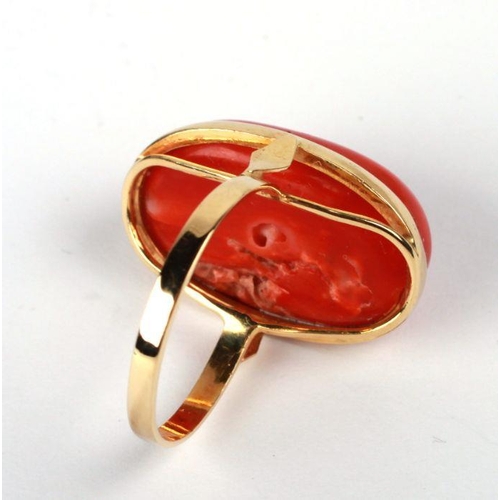 652 - An 18ct gold ring set with a large coral cabochon, approx UK size 'O', 6.7g.