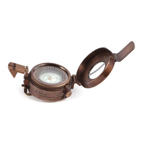 85 - A WWII style military field compass; together with assorted military cap badges.