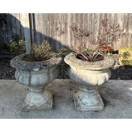 7 - A pair of reconstituted stone planters of classical urn form, each 40cms diameter. (2).