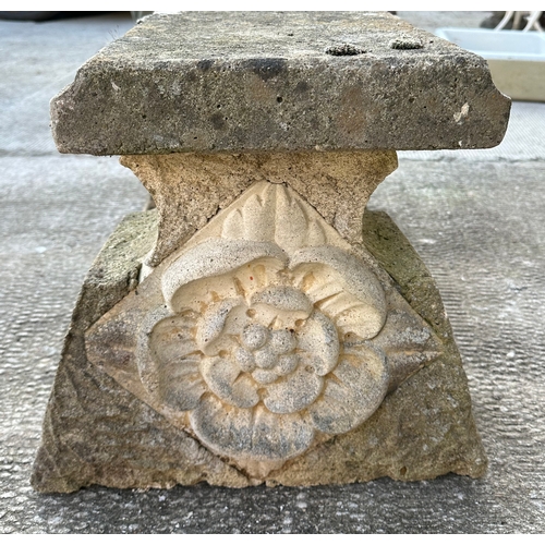 4 - A reconstituted stone bench, the rectangular top on cast supports with rose decoration, 92cms wide.