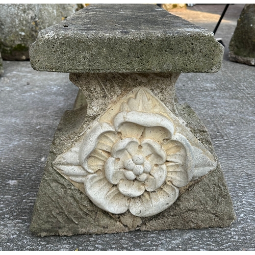 4 - A reconstituted stone bench, the rectangular top on cast supports with rose decoration, 92cms wide.