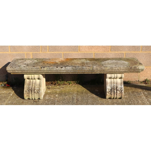 28 - A large and very heavy well weathered reconstituted stone bench on scroll supports, 168cms.