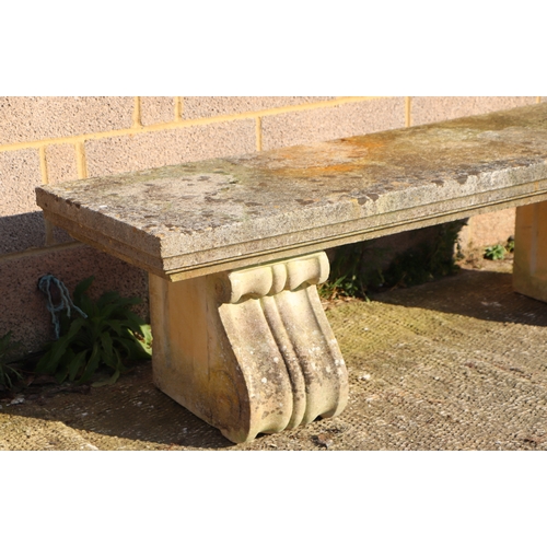 28 - A large and very heavy well weathered reconstituted stone bench on scroll supports, 168cms.