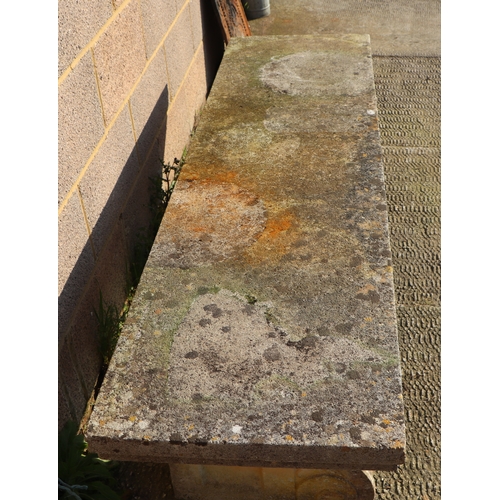 28 - A large and very heavy well weathered reconstituted stone bench on scroll supports, 168cms.