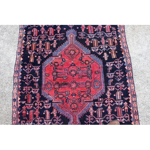 287 - A Persian hand knotted rug with stylised design, on a blue ground, 183 by 110cms (68).