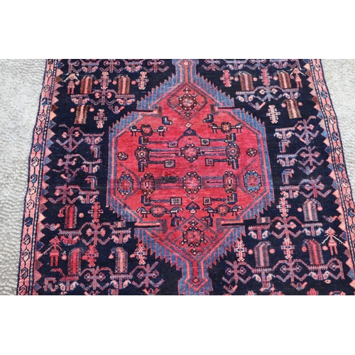 287 - A Persian hand knotted rug with stylised design, on a blue ground, 183 by 110cms (68).