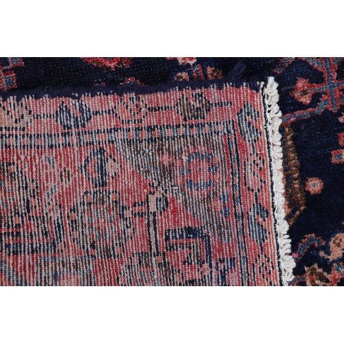 287 - A Persian hand knotted rug with stylised design, on a blue ground, 183 by 110cms (68).