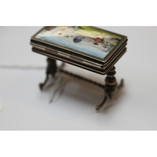 589 - An Edwardian miniature silver & enamel box modelled as an occasional table on turned supports joined... 