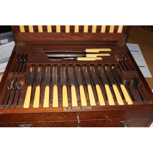 549 - An oak canteen containing Old English Pattern silver plated cutlery, 45cms diameter.