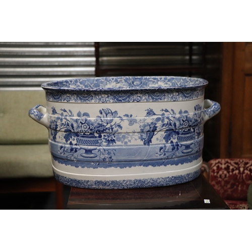 442 - A 19th century blue & white two-handled footbath decorated with flowers within urns, 54cms wide.