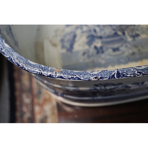 442 - A 19th century blue & white two-handled footbath decorated with flowers within urns, 54cms wide.