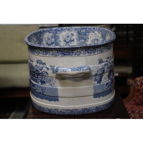 442 - A 19th century blue & white two-handled footbath decorated with flowers within urns, 54cms wide.