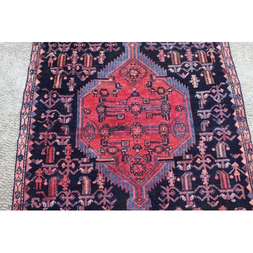 141 - A Persian hand knotted rug with stylised design, on a blue ground, 183 by 110cms (68).