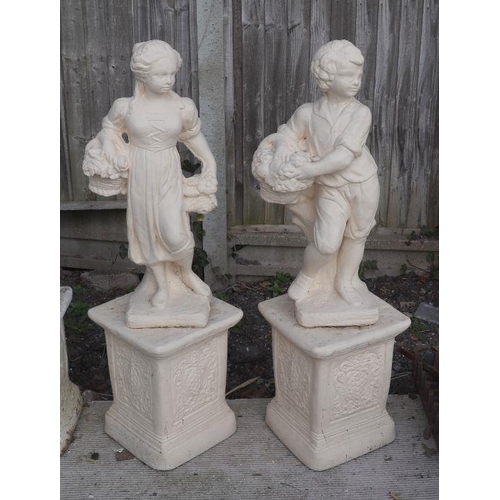 3 - A matched pair of reconstituted stone figures depicting a boy and girl carrying baskets of flowers, ... 