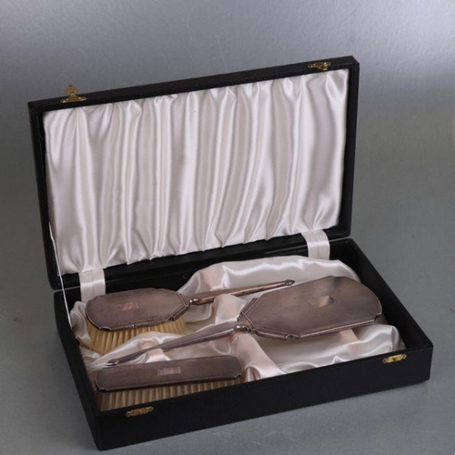 484 - A cased three-piece silver dressing table set, Birmingham 1960.