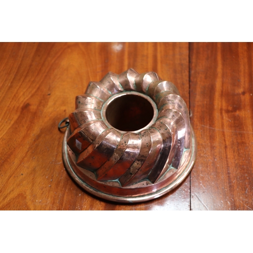 394 - A Victorian copper jelly mould, 23cms diameter; together with a copper pan and cover, 17cms wide; an... 