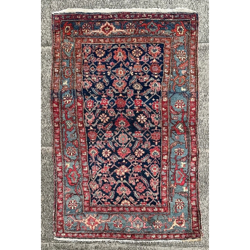 120 - A Northwest Persian Bijar rug with repeating floral motifs on a dark blue ground within a multi bord... 