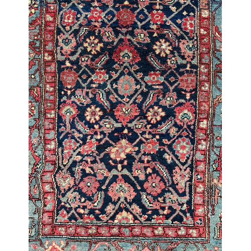 120 - A Northwest Persian Bijar rug with repeating floral motifs on a dark blue ground within a multi bord... 