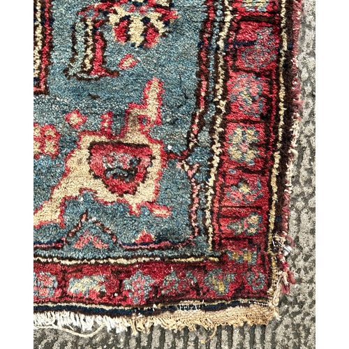 120 - A Northwest Persian Bijar rug with repeating floral motifs on a dark blue ground within a multi bord... 