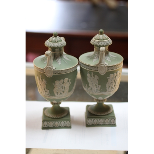 347 - A pair of Wedgwood green classical Jasperware urns and covers decorated with figures, 20cms high; to... 