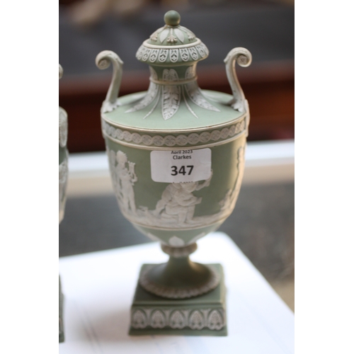 347 - A pair of Wedgwood green classical Jasperware urns and covers decorated with figures, 20cms high; to... 