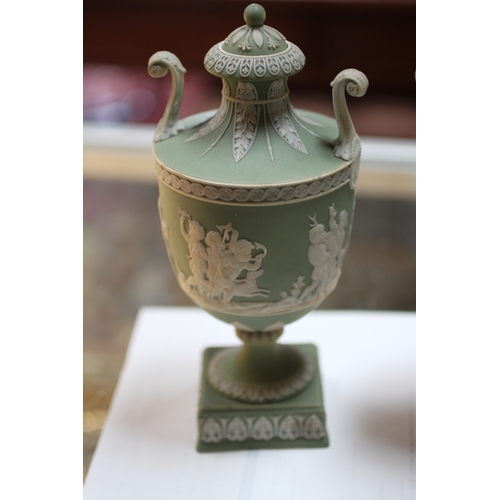 347 - A pair of Wedgwood green classical Jasperware urns and covers decorated with figures, 20cms high; to... 