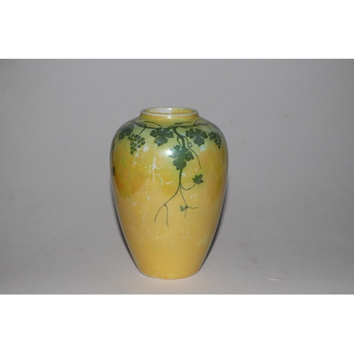 315 - A Ruskin pottery vase decorated with grape and vine, on a yellow ground, 15cms high.