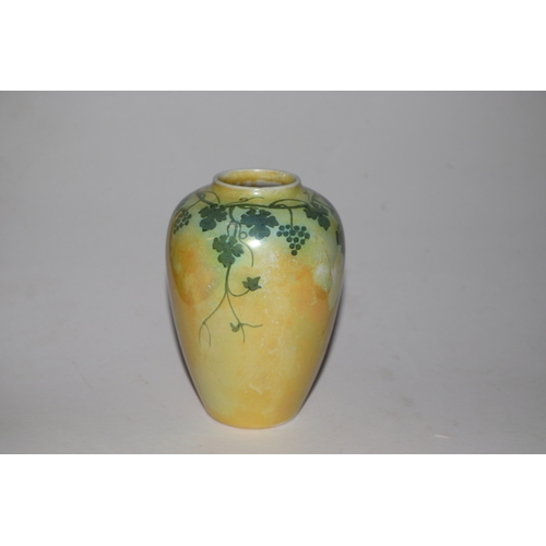 315 - A Ruskin pottery vase decorated with grape and vine, on a yellow ground, 15cms high.