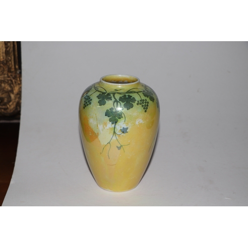 315 - A Ruskin pottery vase decorated with grape and vine, on a yellow ground, 15cms high.