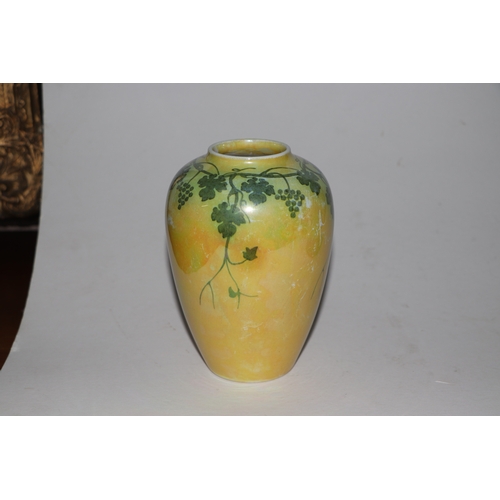 315 - A Ruskin pottery vase decorated with grape and vine, on a yellow ground, 15cms high.