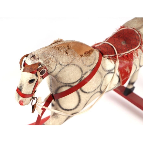 124 - An early 20th century straw filled rocking horse, possibly German. 105cm long (a/f)