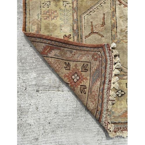 176 - A Persian hand knotted rug decorated with a geometric pattern on a beige ground, 196 by 281cms.