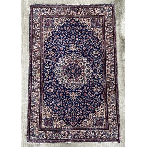 178 - A Persian rug with geometric floral design on a blue ground within a multi border, 130 by 210cms.