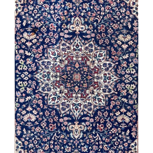 178 - A Persian rug with geometric floral design on a blue ground within a multi border, 130 by 210cms.